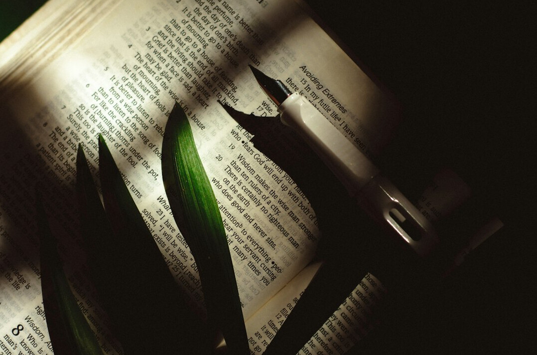 Open book with a pen on a table in soft light